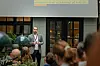 Man speaking to an audience indoors at a technology event.